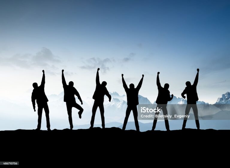 silhouettes of team on mountain peak. sport and active life concept.